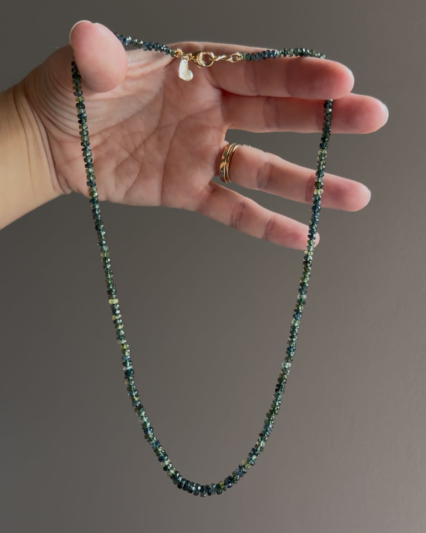 Full 18-inch graduated green Montana sapphire necklace showing faceted gemstone beads and gold findings