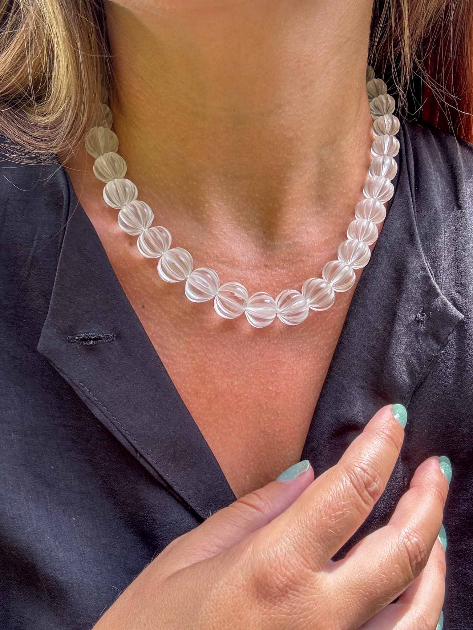 Clear beaded necklace worn by a person with a blurred background