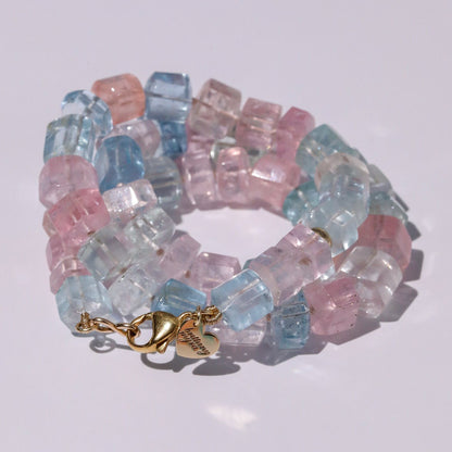 Detail of 14K gold lobster clasp with engraved heart tag on aquamarine necklace
