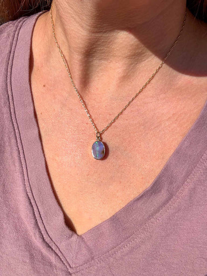 Necklace with a pendant worn by a person in a purple shirt