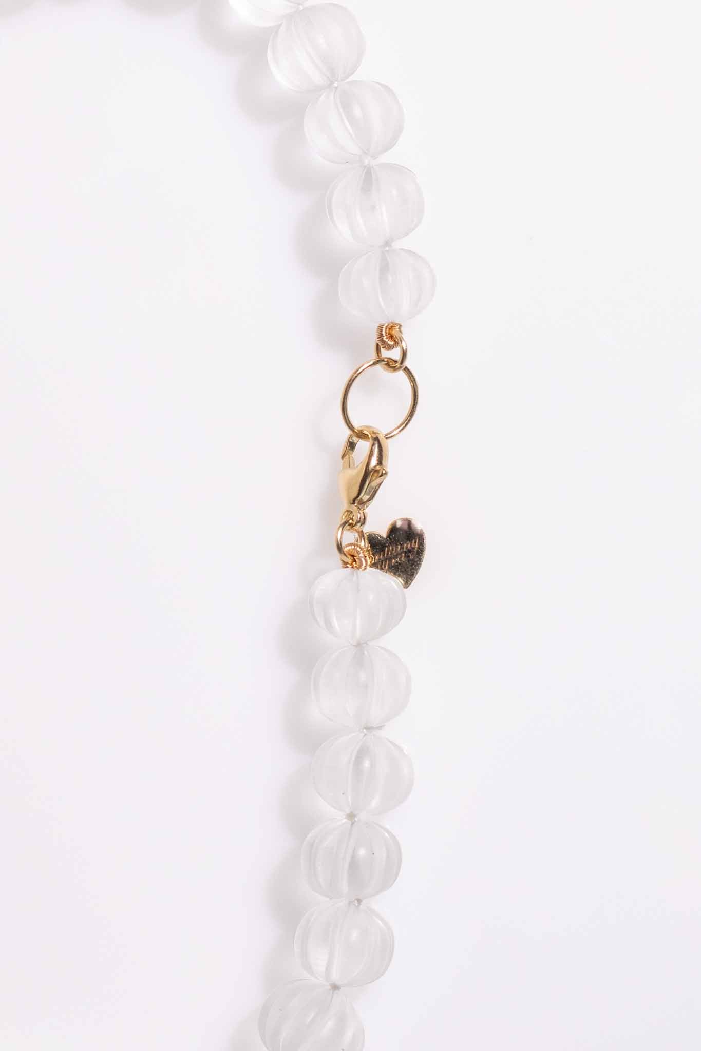 White beaded necklace with a gold clasp on a white background Carved Quartz Pumpkins 14k Gold Knotted Candy Bead Necklace