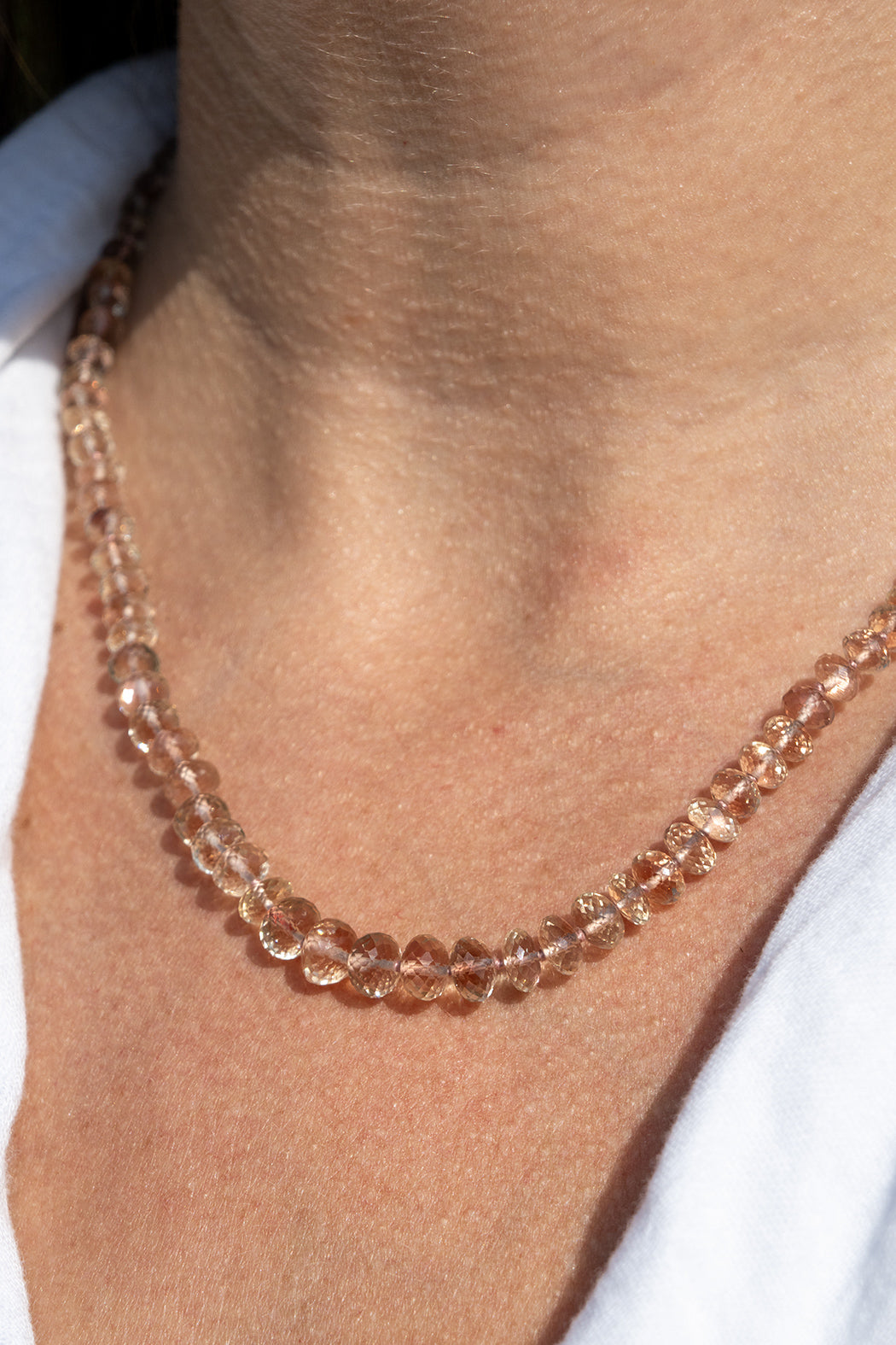 Close-up of a person wearing a rose gold beaded oregon sunstone schiller necklace. genuine oregon sunstone peach red schiller beaded gemstone necklace fine 14k gold jewelry minimalist necklace