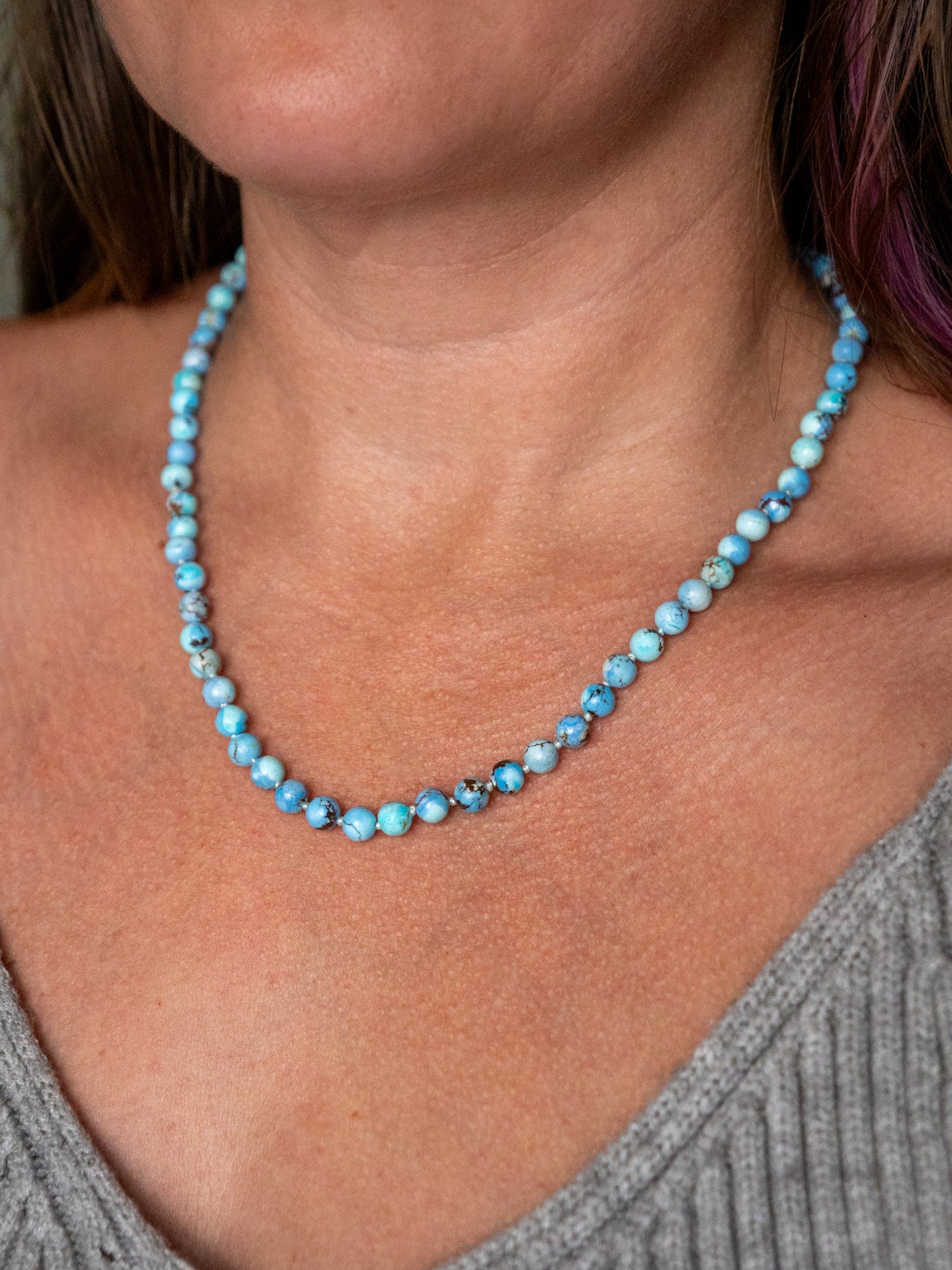 Close up of a Kazakhstan turquoise beaded necklace worn on the collarbone