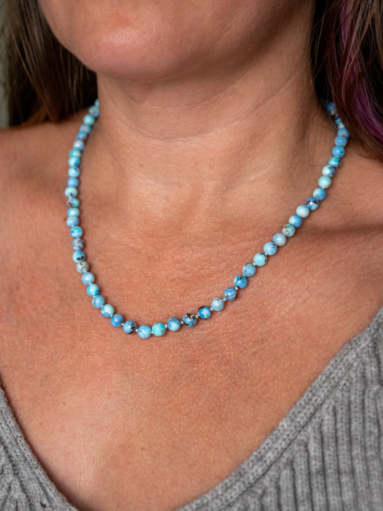 Close up of a Kazakhstan turquoise beaded necklace worn on the collarbone