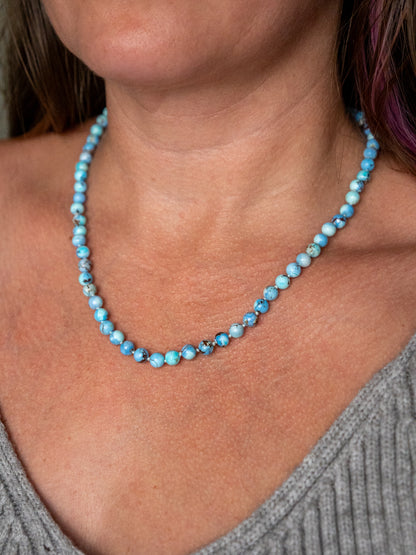 Close up of a Kazakhstan turquoise beaded necklace worn on the collarbone