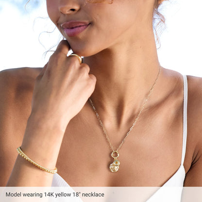 Woman wearing a gold necklace with a pendant, with text indicating the necklace's details.