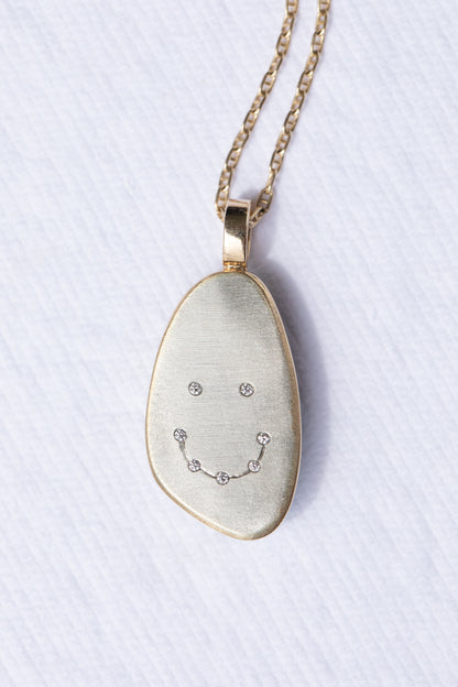Variscite and diamond pendant showing seven diamonds flush set in a smiley face on the back